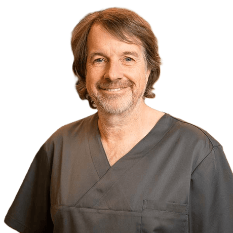 Dr. Claudio Cacaci German oral surgeon and implantology expert smiling in dark scrubs professional portrait