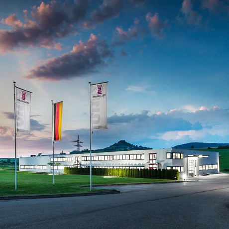 Helmut Zepf Dental Instrument headquarters at dusk with German flag and company flags flying outside modern facility