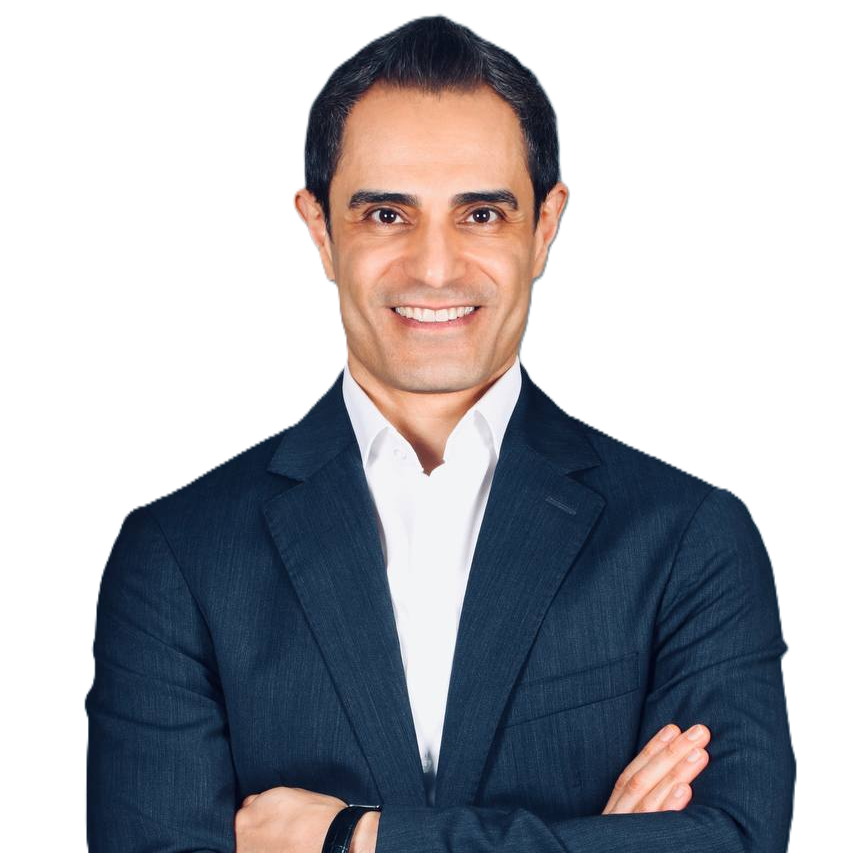 Dr. Behnam Shakibaie Instrument collection creator smiling in a navy suit with arms crossed